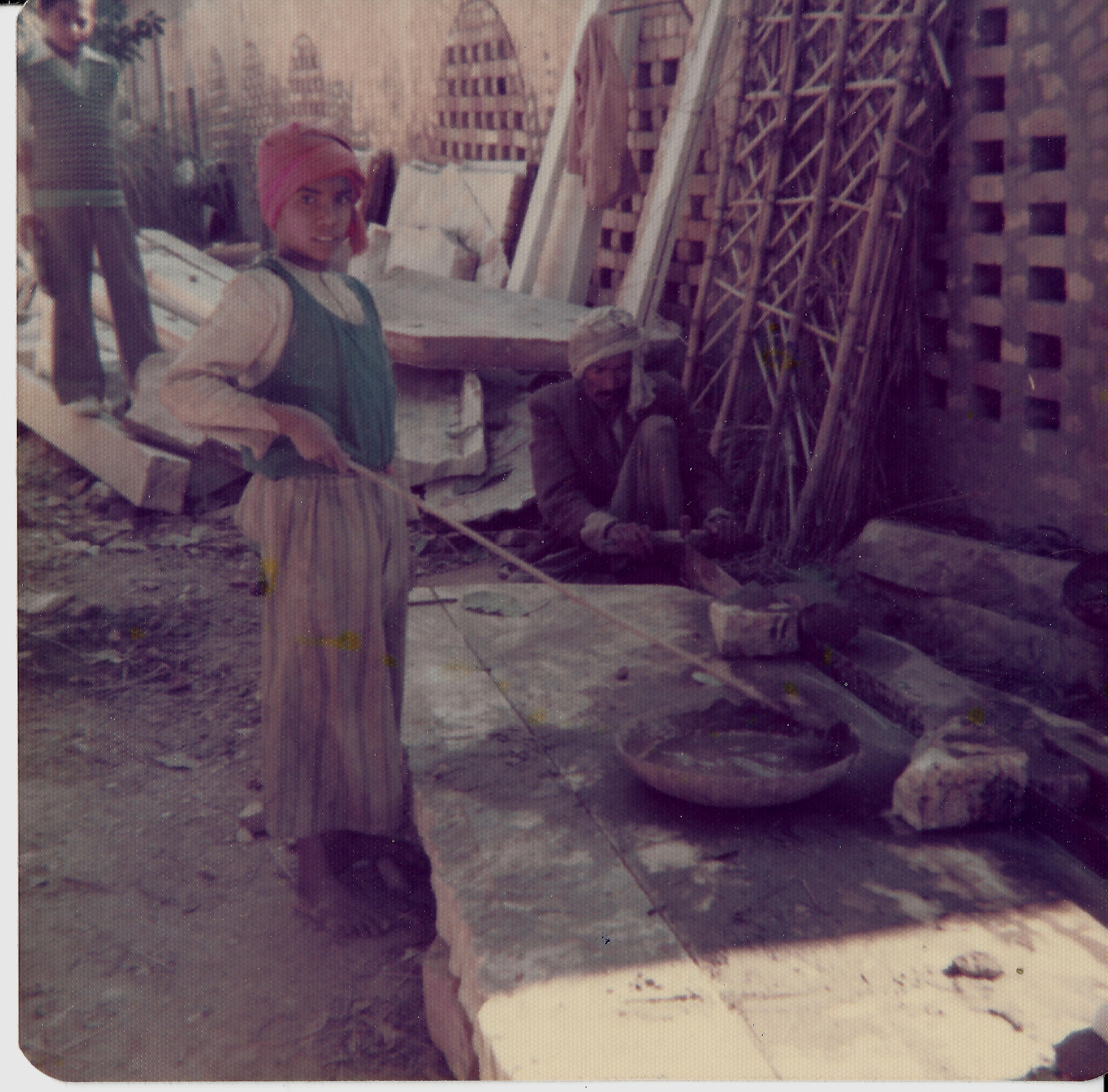 A young boy standing in front of construction materials.