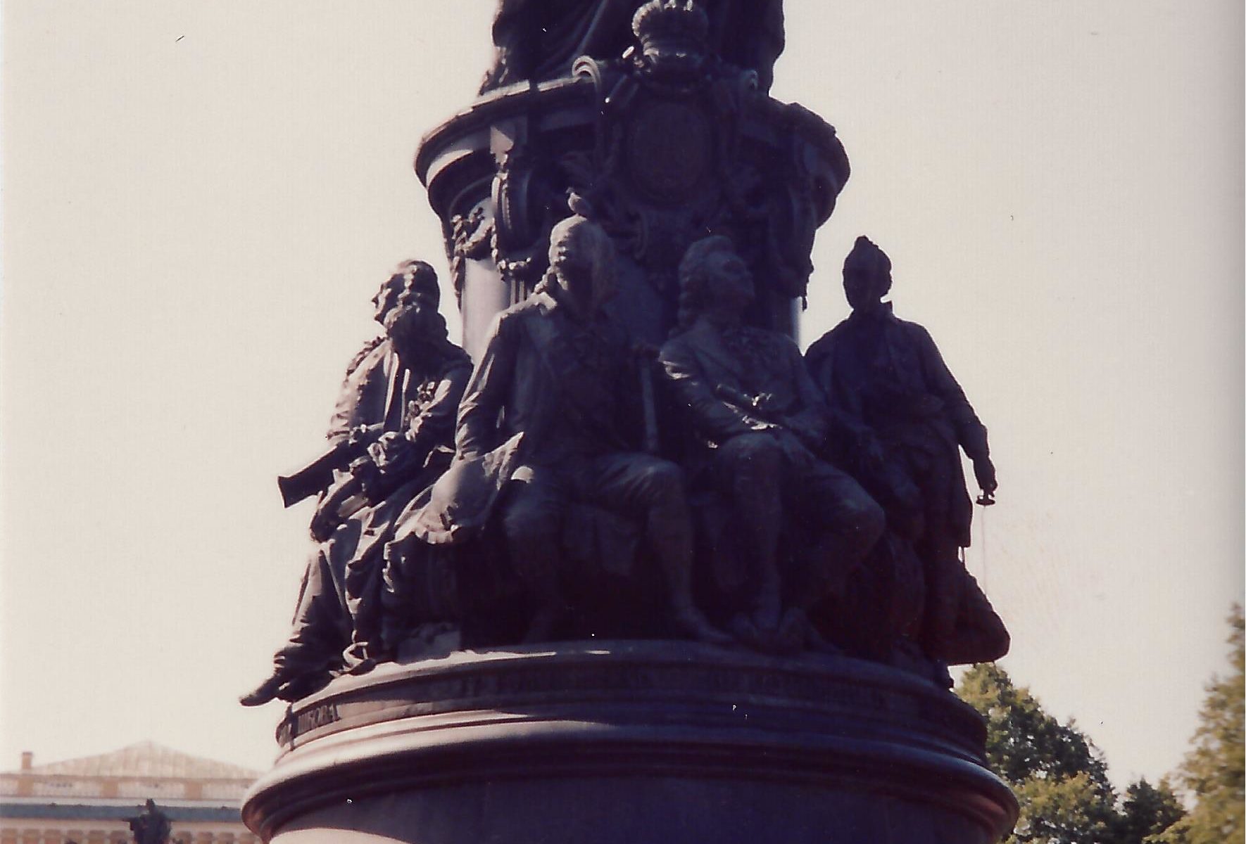 A statue of people sitting on top of a bell.