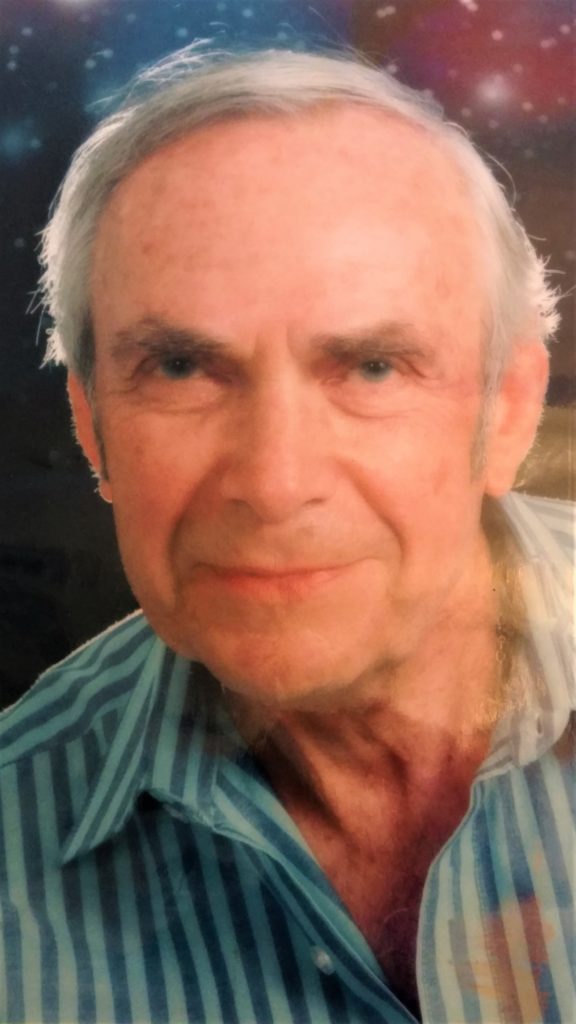 Elderly man with striped shirt, smiling gently.